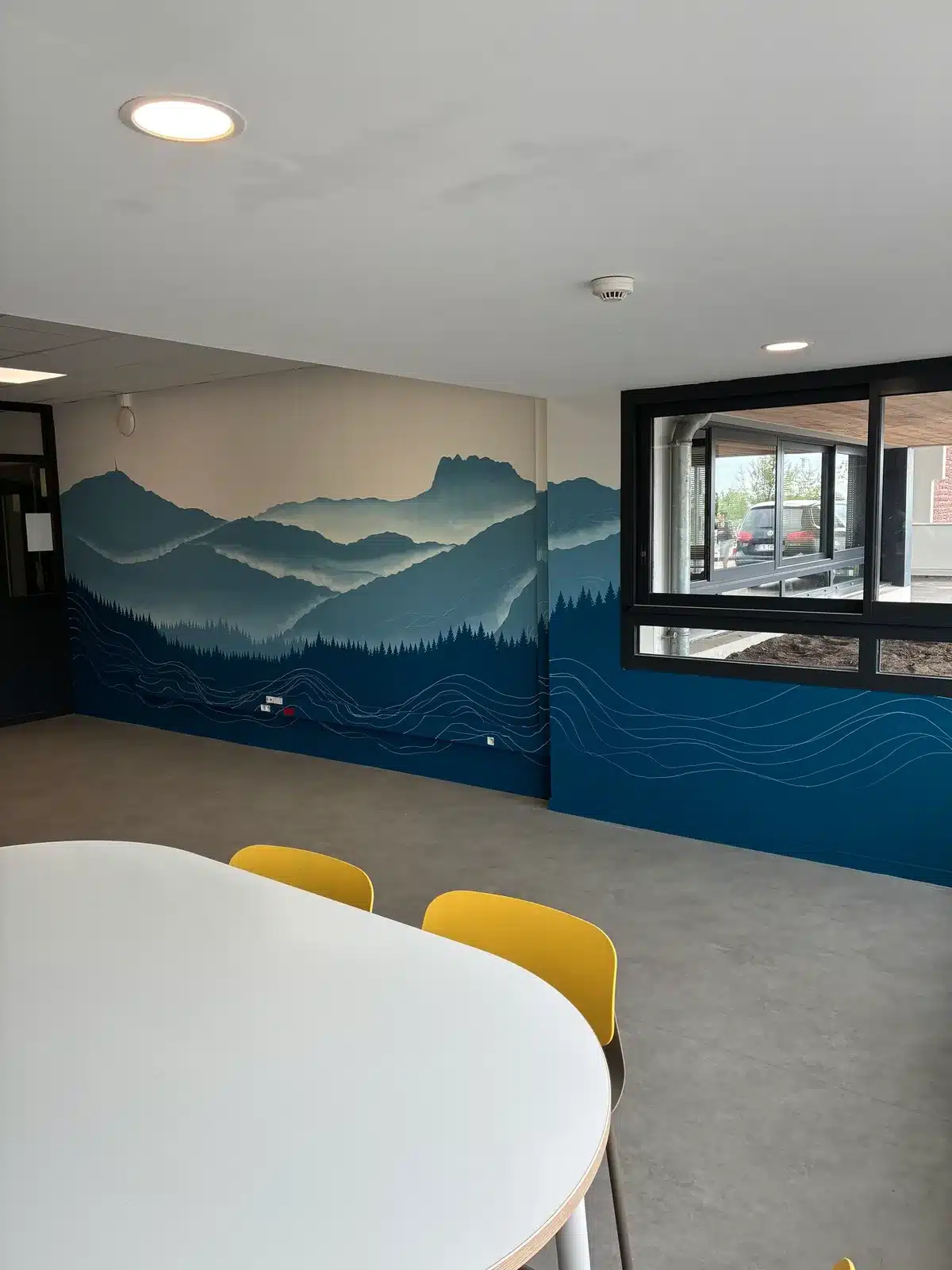 Fresque murale personnalisée de montagnes bleues et de vagues dans une salle de pause professionnelle